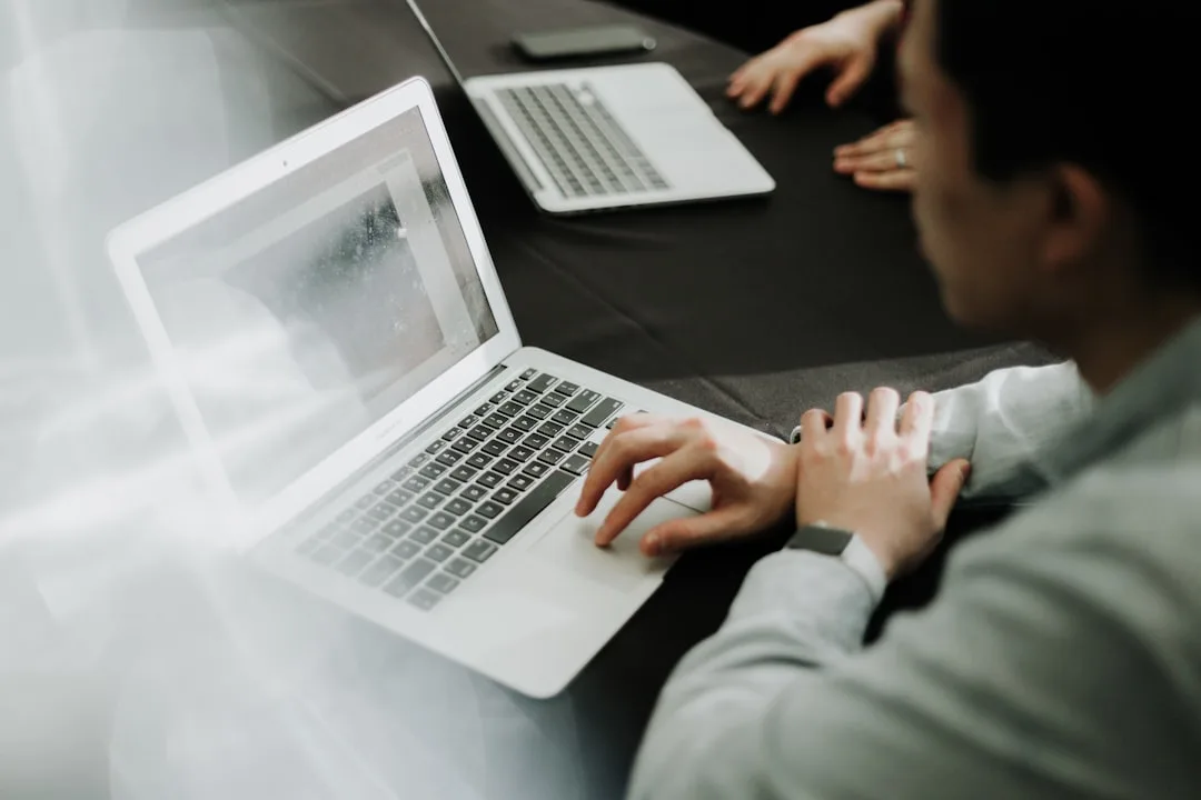 A person sitting at a table with a laptop, working on email marketing.