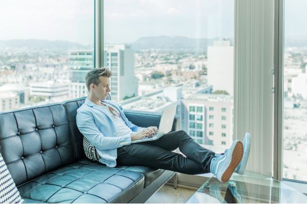 Man sitting on a couch, focused on his laptop, highlighting the importance of semantic search for business growth.