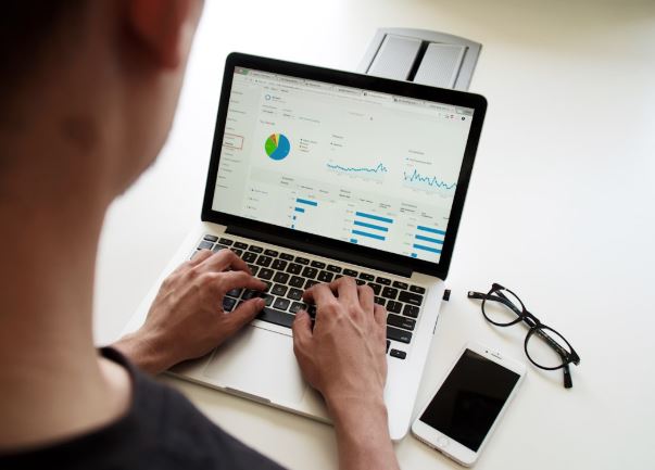 A man analyzing a performance graph on his laptop to improve campaign effectiveness.