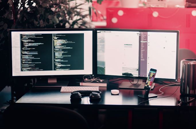 Desk with two monitors, illustrating a productive work environment.