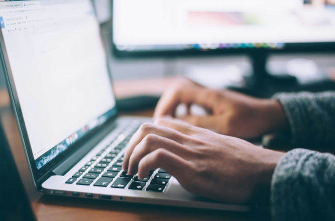 Content creator typing on laptop, developing strategy for AI-powered search optimization