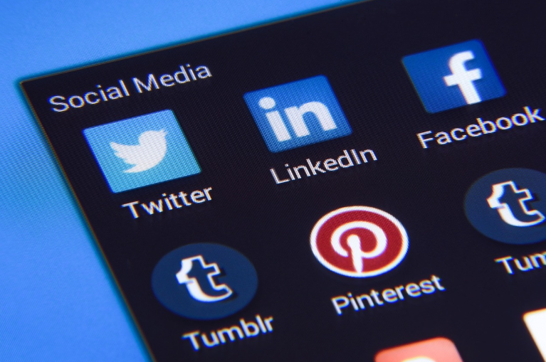 Close-up of social media app icons including Twitter, LinkedIn, Facebook, Pinterest, and Tumblr used for digital promotion