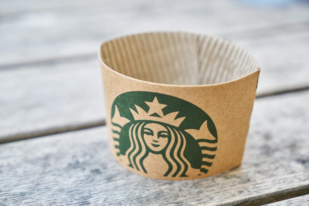 Starbucks branded coffee sleeve on wooden table symbolizing strong customer loyalty and personalized brand experience