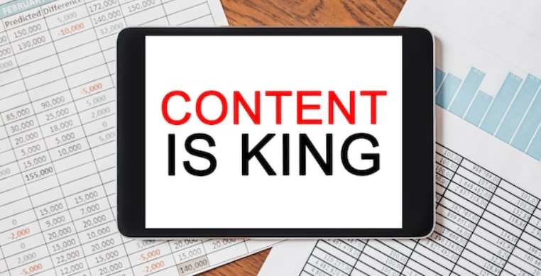Tablet showing content is king with business charts for blogging tips and strategy