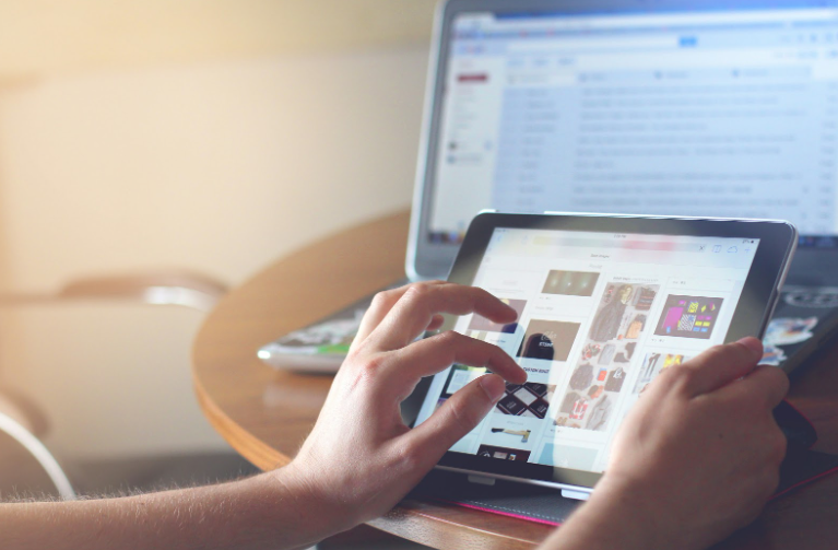 Person browsing user-generated content on tablet and laptop