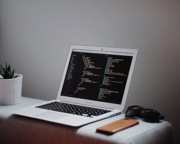 Open laptop displaying CSS code editor, showing website styling and responsive design principles in action.