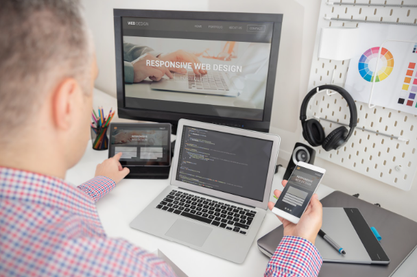 Developer testing responsive website design on multiple devices for mobile optimization