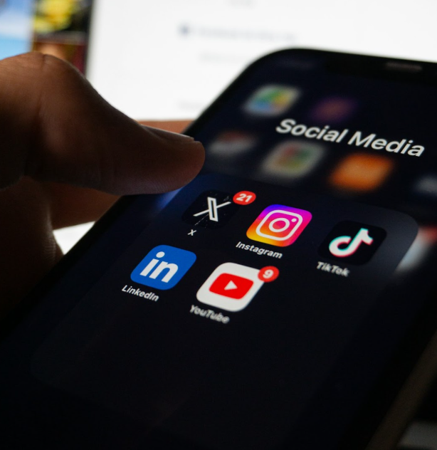 Social media apps on smartphone screen including Instagram, TikTok, LinkedIn, and YouTube